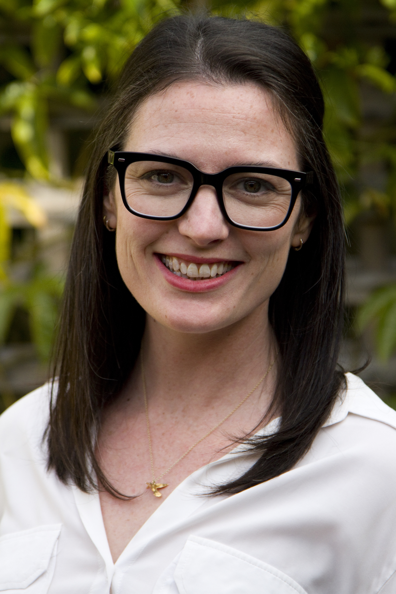 Head and shoulders photo of Lauren Faller, a white woman with shoulder-length dark hair and thick, black-rimmed glasses